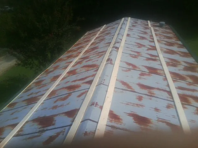 Rusted metal roof panels with new wood purlins before replacement — Storm Damage Roof Repair in Sweetwater by Roofing Brothers